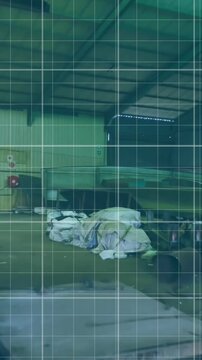 Grid pattern animation over industrial workshop with various equipment and materials