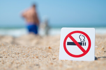 No Smoking sign. Smoking is prohibited in public places. Prohibitory sign against the background of sand and sea, ocean. Attention, smoking is prohibited.