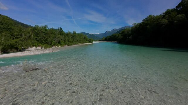 Picturesque river Socha in the Slovenian mountains. Clean turquoise water of the fast stream in the Alps in Slovenia. Fpv drone video of European nature in the bright sunny day 