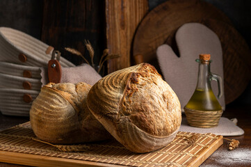 Healthy, organic, whole and sliced ​​homemade sourdough bread with ham and cheese on a wooden table and kitchen utensils with an airy crumb and crispy crust. 
