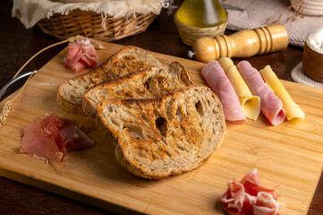 Healthy, organic, whole and sliced ​​homemade sourdough bread with ham and cheese on a wooden...