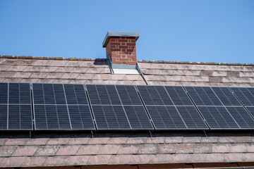 Solar panels installed on tiled roof of residential house in sunny weather