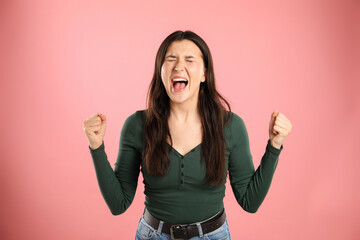 Fototapeta premium Portrait of emotional woman on pink background