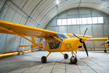 Yellow airplane glider in the hangar. 