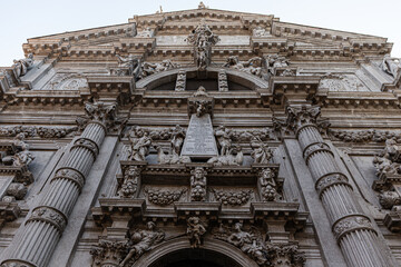 A powerful, low-angle shot capturing the intricate details of the Baroque facade of the San Moisè...