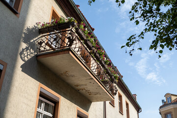 Historic Balcony with Flowers in Sunlight, Olsztyn Old Town, Poland