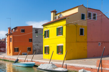 Burano island canal, colorful houses and boats in the Venice lagoon. Italy