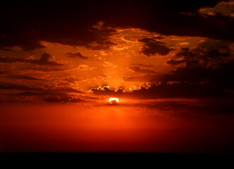 Fiery Sunset Behind Dramatic Clouds