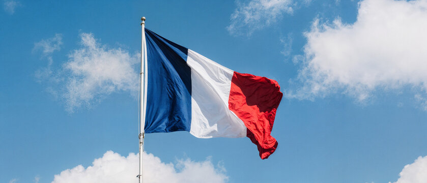 Drapeau fran&ccedil;ais flottant fi&egrave;rement dans le ciel bleu &eacute;clatant - banni&egrave;re grand format pour les actualit&eacute;s sur la c&eacute;l&eacute;bration de la F&ecirc;te nationale en France