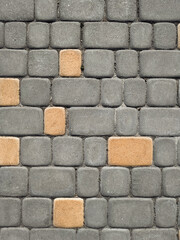 Texture of dark gray granite paving stones and sand with shell rock between them, top view. Background from natural block stone.