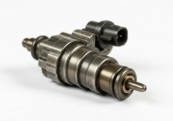 Close up of a metal fuel injector with a black connector on a plain white background studio shot