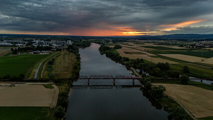 Sonnenuntergang über dem Fluss, von einer Anhöhe aus mit Blick auf die Brücke und die Landschaft...