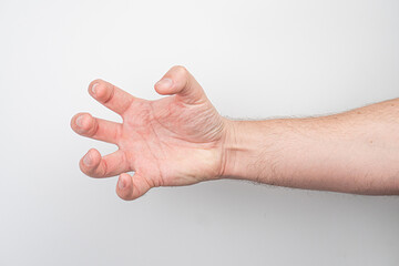 Close-up of an older persons arm, making a hand gesture resembling a claw or symbol, against a...
