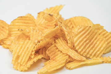 Close-up image of golden brown, crispy potato chips on neutral background Varied textures with...