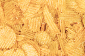 Close-up view of piled potato chips, varying shades of yellow, curled edges, natural lighting, depth, texture.
