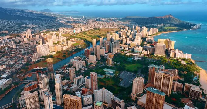 Beautiful cityscape of Honolulu at sunset time. Drone footage over Waikiki resort. Koko head crater at backdrop.