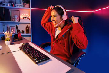 Host channel of smiling beautiful Asian girl streamer playing with raising fist up winning on...