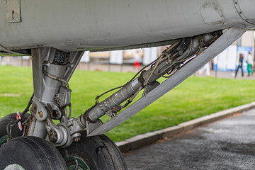 Close-up view of an extended landing gear and engine area of a jet passenger airplane Muted grays...
