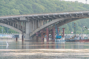 Overcast sky over a multi-span bridge on the Dnepr River in Kiev The large, robust structure...