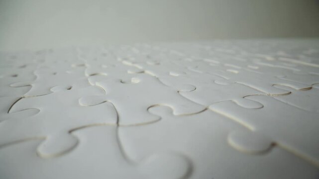 Fingers placing last puzzle finishing closeup. Unknown person assembling jigsaw