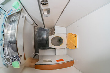 Small aircraftspacecraft lavatory with a sink, waste bin, and control panel-like object Subdued...
