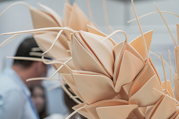 A tranquil indoor scene, showcasing two paper sculptures in a light-colored material One has a...