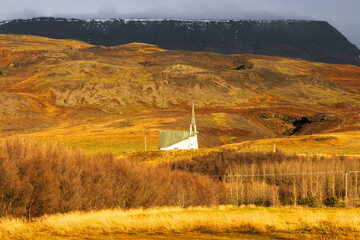 Kirche in Island bei Sonnenuntergang, warmes Licht der untergehenden Sonne beleuchtet das Gebäude...