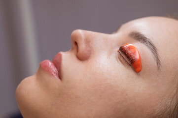 Caucasian woman undergoing eyelash lamination procedure. 
