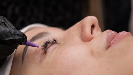 The process of professional eyelash lamination in a salon. 