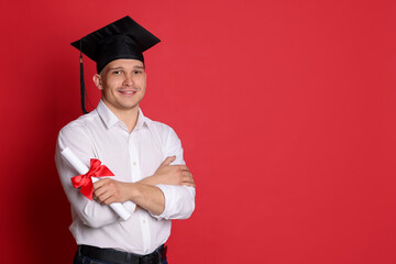 Happy student with diploma after graduation on red background. Space for text