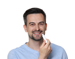 Smiling man applying lip balm onto his lips on white background