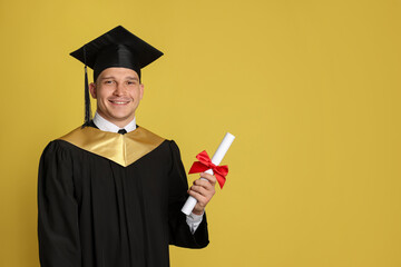 Happy student with diploma after graduation on yellow background. Space for text