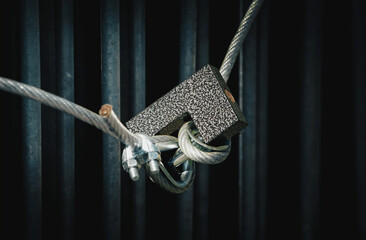 A closed padlock hangs on the grate