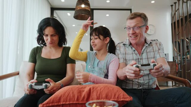 Granddaughter guide grandmother how to play console game with grandfather. Senior use technology activity communicate new generation kid cross generation gap strengthen family bond. Divergence.