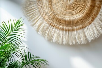 Straw wall hanging with circular woven pattern and palm leaves in sunlight.