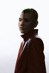 young woman with colorful braided hair in a red jacket facing sideways, minimalistic white...