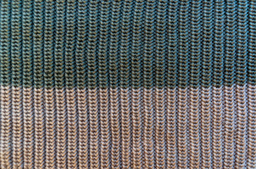 Knitted fabric with texture and two-tone pattern.The texture of a knitted sweater.