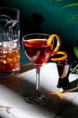 vibrant cocktail in stylish glass, garnished with twist of citrus peel, against a backdrop of a dimly lit ambiance.