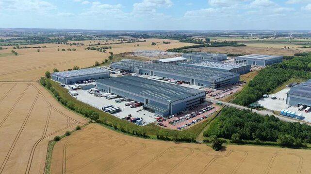 Aerial drone perspective distribution centers and industrial warehouses and data centers centres Quantum computing business hub super market distributor near Biggleswade England UK