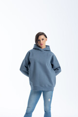 Portrait beautiful woman of model appearance. Girl in grey sweatshirt on grey background. Pretty...