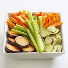 A front-facing photo of a clean white square bowl filled with neatly arranged vegetables cut in different shapes: sweet potato strips, celery pieces, eggplant rounds, and potato strips