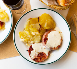 Delicious fried turkey escalopes with spicy Roquefort cheese sauce and side dish of potatoes