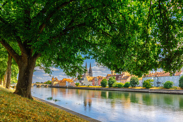 Obraz premium Panoramic view on beautiful Stone Bridge, Cathedral and Old Town. River Danube with colorful reflection, Regensburg, Bavaria, Germany. High quality photo