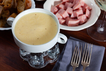 National swiss food, cheese fondue with bread, ham, olives and wine
