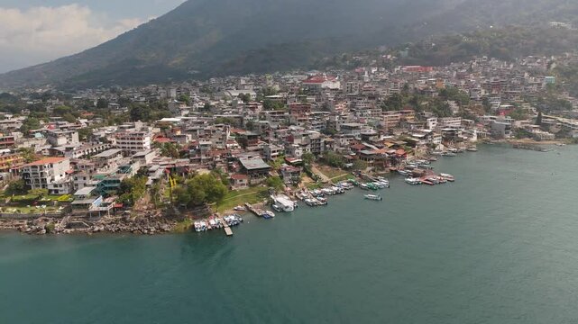 Aerial view of lakeside town and marina on Lake Atitlan surrounded by mountains, Guatemala