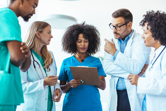 Medical Team Collaborating and Reviewing Patient Information on a Clipboard