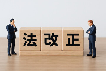 法改正を議論するビジネスマンのミニチュア模型