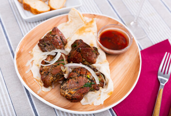 Traditional georgian dish shish kebab or shashlik, grilled pork meat served with pickled onion and flatbread