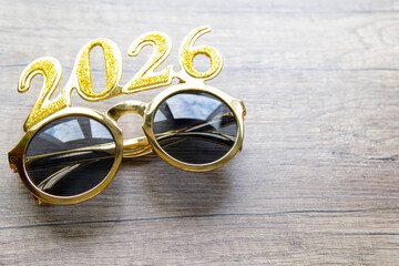 happy new year 2026 with copy space for new year resolutions glasses with numbers 2026 on wooden desk.