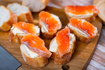 Making delicious sandwiches with butter and salmon on white bread